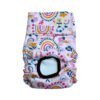 Vista frontal del pañal reutilizable para perrita, modelo Arco de Sol, con estampado de arcoíris en tonos mostaza, rosa y azul, junto a flores y formas decorativas sobre fondo rosa