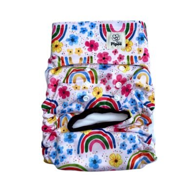 Vista frontal del pañal reutilizable para perrita, modelo Arcoíris Floral, con estampado de arcoíris multicolor y flores en tonos rosados, amarillos y azules sobre fondo blanco