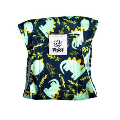 Vista frontal del pañal reutilizable para perro macho modelo Dinolandia, tipo fajín con estampado de dinosaurios verdes y hojas tropicales sobre fondo oscuro