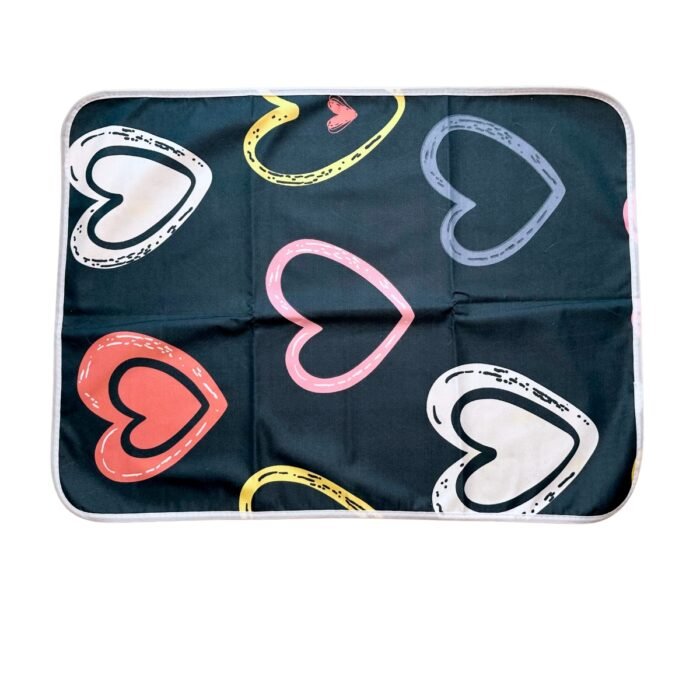 Vista superior del pad de piso reutilizable para perros modelo Corazones, con diseño de corazones en tonos rosados y blancos sobre fondo oscuro. Pad de piso reutilizable para perros – modelo Corazones