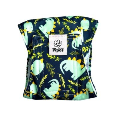 Vista frontal del pañal reutilizable para perro macho modelo Dinolandia, tipo fajín con estampado de dinosaurios verdes y hojas tropicales sobre fondo oscuro Pañal reutilizable para macho – modelo Dinolandia